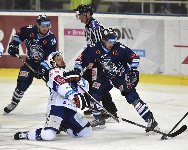 Martin Zaťovič z Brna (uprostřed) se kácí na led v obležení libereckých soupeřů Filipa Pyrochty a Milana Bartoviče ve finále play off hokejové extraligy.