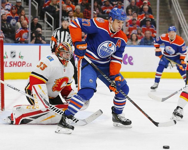 Útočník Edmontonu Milan Lucic (27) zkouší tečovat puk před brankou Calgary, kterou hájil český gólman David Rittich (33).