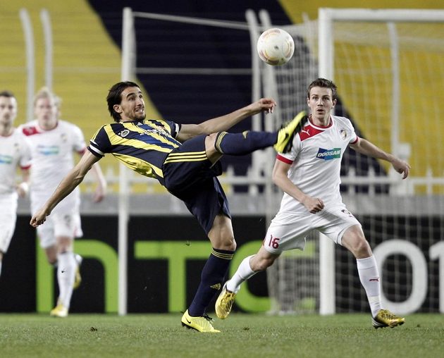 Mehmet Topal z Fenerbahce odkopává míč, vpravo přihlíží plzeňský Vladimír Darida.