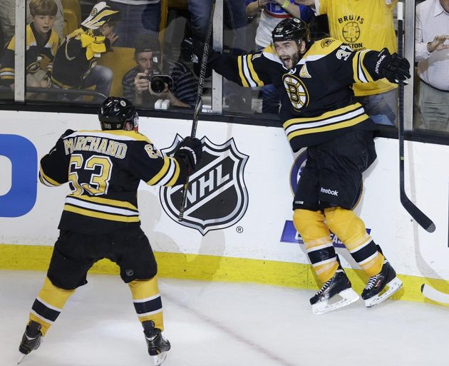 Útočník Bruins Patrice Bergeron (37) a jeho spoluhráč Brad Marchandd (63) slaví vítězný gól Bostonu v třetím zápase proti Pittsburghu Penguins.