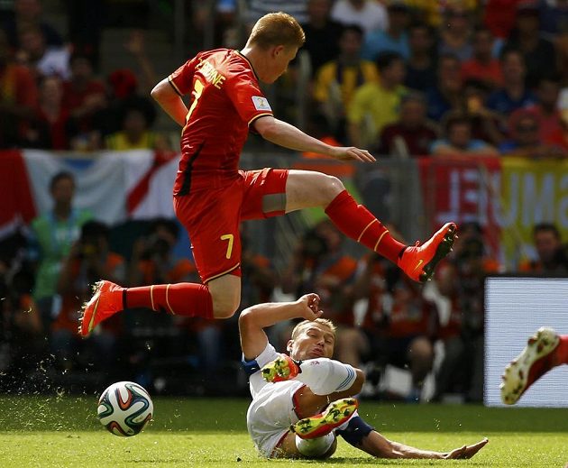 Belgičan De Bruyne přeskakuje Rusa Berezuckého v zápase skupiny H na MS v Brazílii.