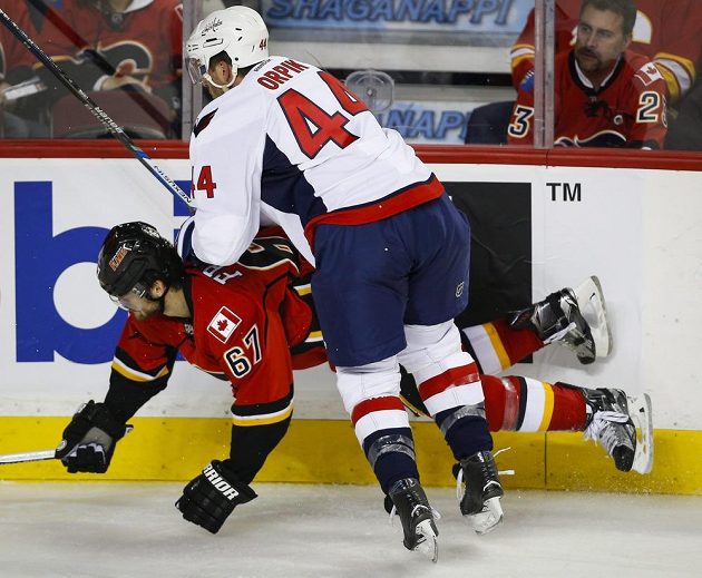 Hokejista Washingtonu Capitals Brooks Orpik (vpravo) při souboji u mantinelu s Michaelem Frolíkem z Calgary.