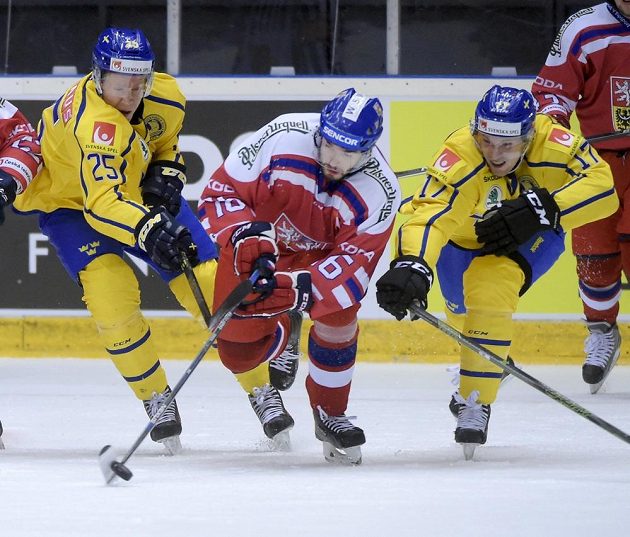 Michal Birner (uprostřed) se snaží dostat puk pod kontrolu, zabránit se mu v tom snaží Švédové Andreas Engqvist (vlevo) a Martin Lundberg.