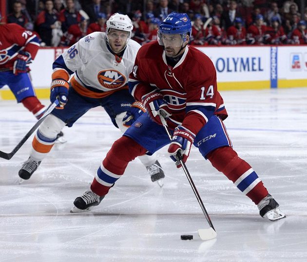 Hokejista Montrealu Tomáš Plekanec (vpravo) se připravuje ke střele v utkání proti New Yorku Islanders. Hosující Nikolaj Kuljomin jen přihlíží.