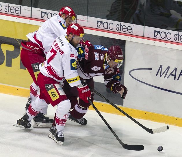 Zleva Lukáš Gavlas a Martin Růžička (oba Třinec) bojují o kotouč s Tomášem Rolinkem (Sparta).