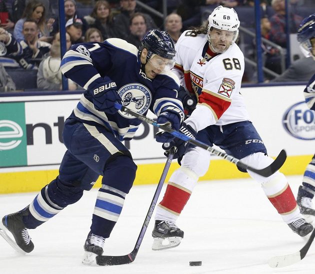 Český útočník Jaromír Jágr v dresu Floridy bojuje v utkání NHL s Jackem Johnsonem z Columbusu Blue Jackets. Florida prohrála 1:2.