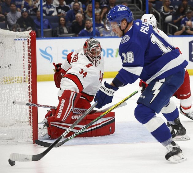 Brankář Caroliny Hurricanes Petr Mrázek (34) v akci proti útočníkovi Ondřeji Palátovi (18) z Tampy Bay Lightning v utkání 2. kola play off NHL.