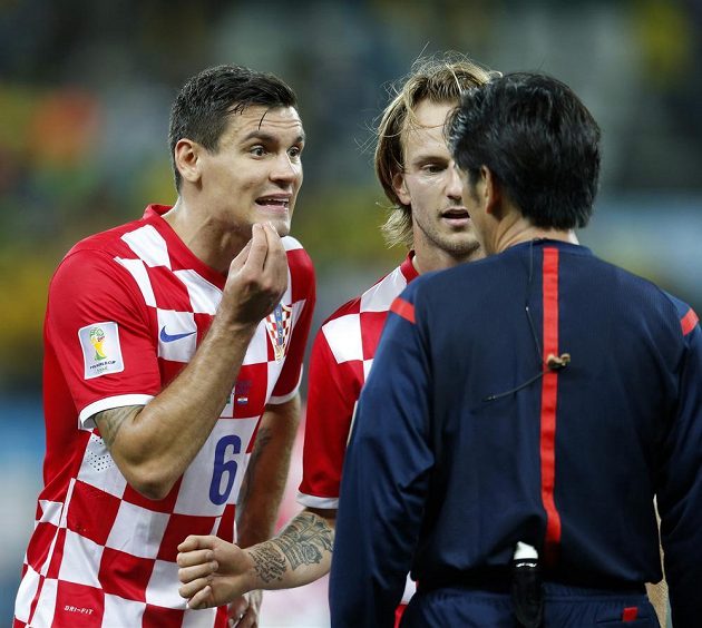 Chorvatští fotbalisté Dejan Lovren (vlevo) a Ivan Rakitič diskutují s japonským sudím Juičim Nišimurou.