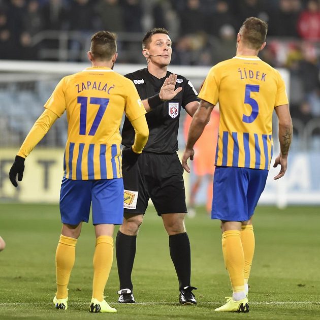 Fotbalisté Opavy Petr Zapalač (vlevo) a Jan Žídek protestují u rozhodčího Ondřeje Pechance, který zápas se Slavií řídil.