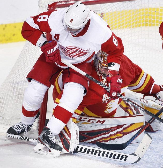 Hokejisté Detroitu Red Wings českého gólmana Calgary Davida Ritticha nešetřili. Před brankou jej atakuje Justin Abdelkader (8).
