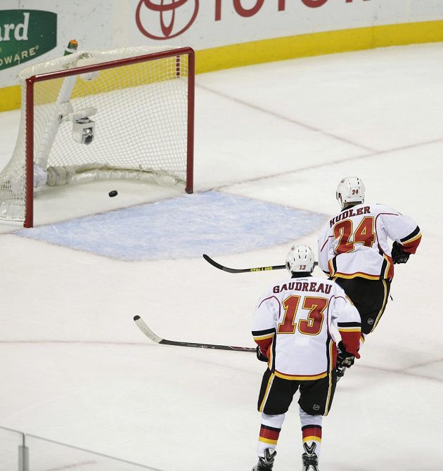 Jiří Hudler (24) pojišťuje vedení Calgary proti San Jose, situaci kontroluje Johnny Gaudreau (13).
