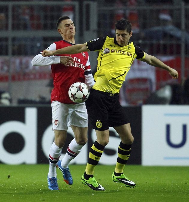 Útočník Borussie Dortmund Robert Lewandowski (ve žlutém) bojuje o míč se zadákem Arsenalu Laurentem Koscielnym.