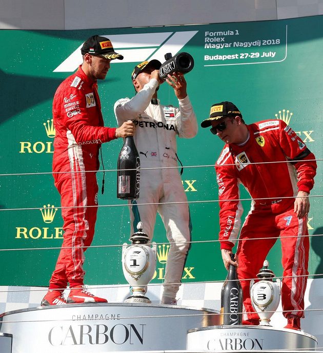 Lewis Hamilton z Mercedesu slaví, doprovází ho konkurence z Ferrari Sebastian Vettel (vlevo) a Kimi Räikkönen.