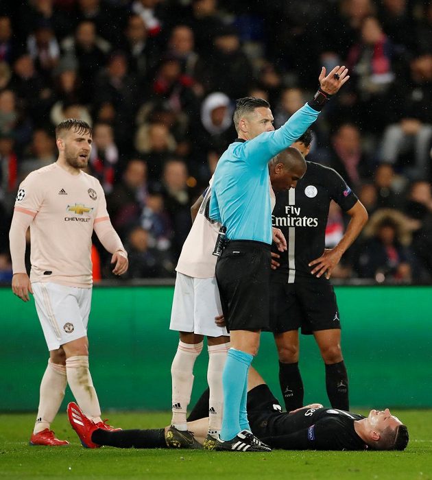 Zraněný Julian Draxler z PSG zůstává ležet, sudí Damir Skomina mu přivolává pomoc.