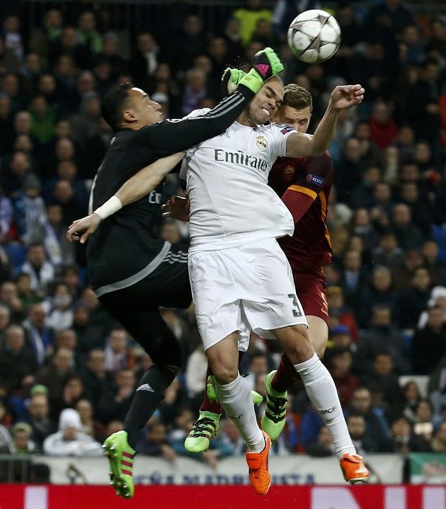 Brankář Realu Madrid Keylor Navas vyráží míč, ve vzdušném souboji Pepé s Edinem Džekem z AS Řím.