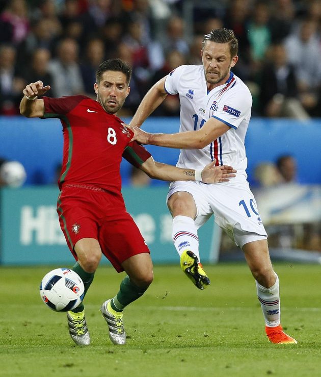 Portugalec Joao Moutinho (vlevo) v souboji s islandským záložníkem Gylfim Sigurdssonem.