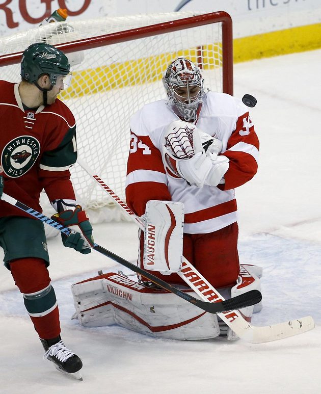 Brankář Detroitu Petr Mrázek zasahuje v zápase proti Minnesotě. Vlevo je útočník Wild Jason Zucker.
