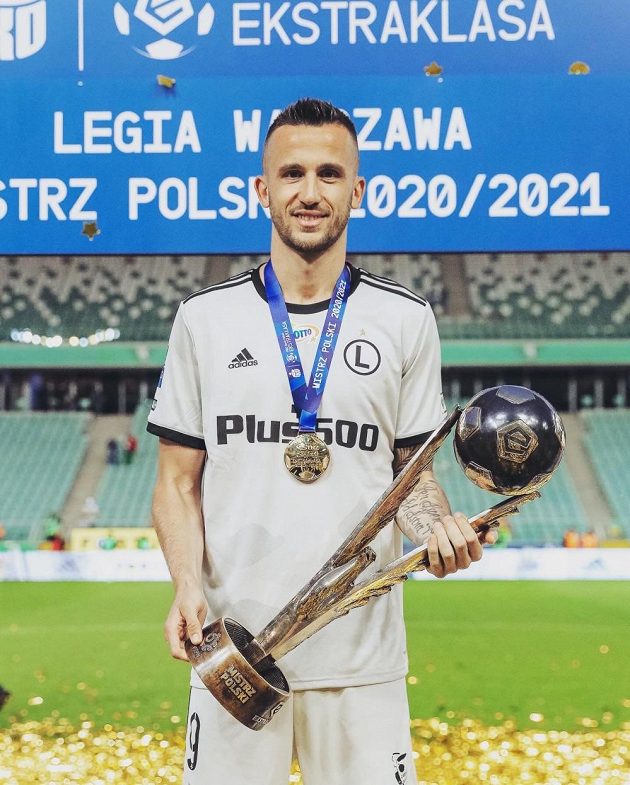 Útočník Legie Varšava s pohárem pro vítěze polské ligy 2020/2021.