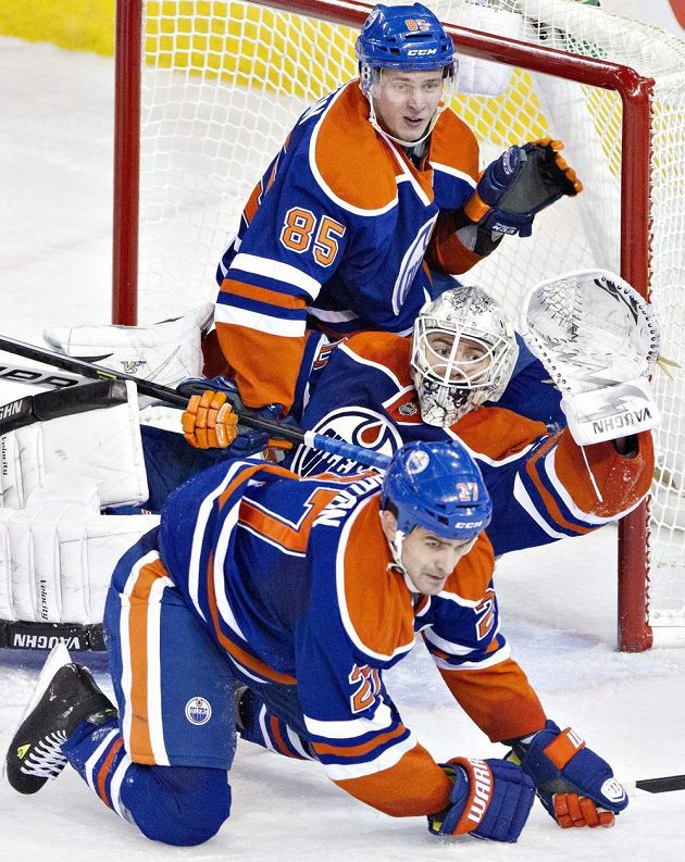 Hráči Edmontonu Boyd Gordon (dole), brankář Ben Scrivens a Martin Marincin se snaží zabránit v inkasování v utkání proti San Jose.
