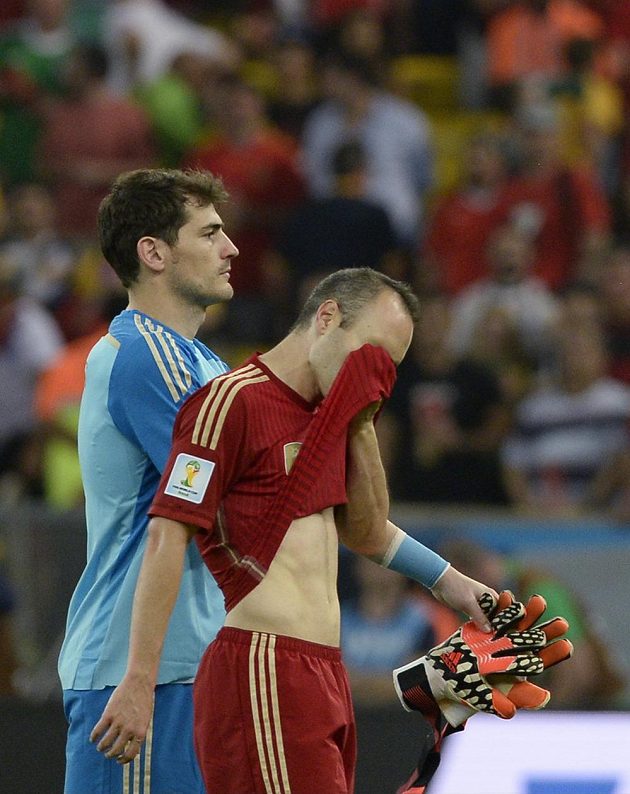 Zklamaní brankář Iker Casillas a záložník Andrés Iniesta opouští po výprasku od Chile trávník slavného brazilského stadiónu Maracaná.