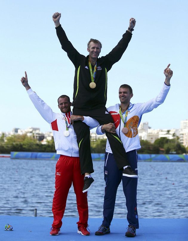 Stříbrný Damir Martin (vlevo) a bronzový Ondřej Synek zvedají nad hlavu olympijského vítěze Mahého Drysdalea.