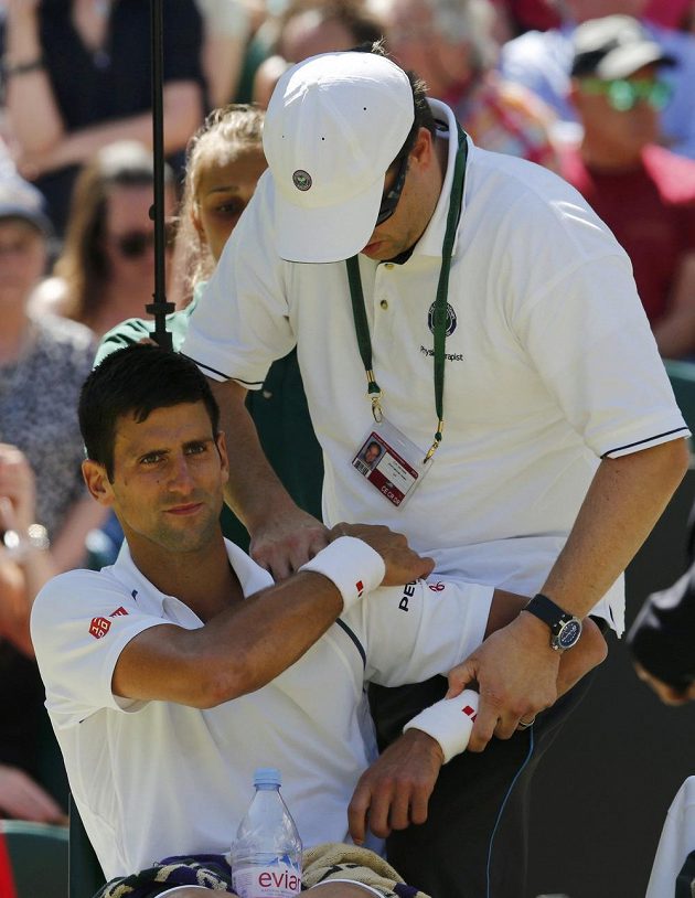 Novak Djokovič ze Srbska při semifinále Wimbledonu s Francouzem Richardem Gasquetem vyhledal pomoc maséra.