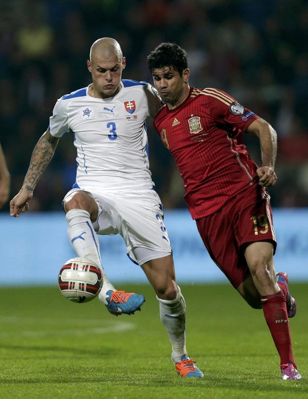 Martin Škrťel ze Slovenska (vlevo) si kryje míč před útočníkem Španělska Diegem Costou.