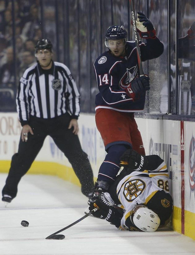 Švýcarský hokejista Dean Kukan v dresu Columbusu Blue Jackets poslal k zemi Davida Pastrňáka z Bostonu v utkání play off NHL.