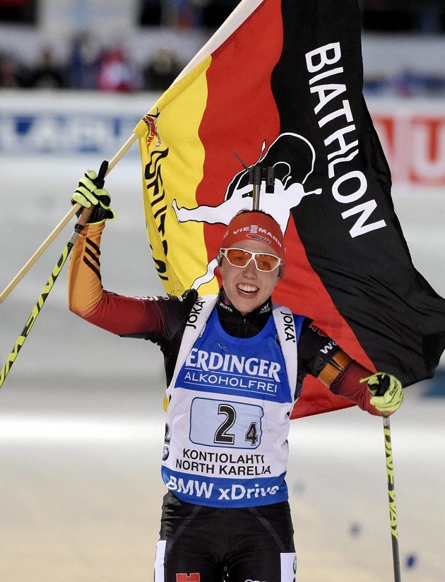 Německá biatlonistka Laura Dahlmeierová slaví s vlajkou vítězství ve štafetě.