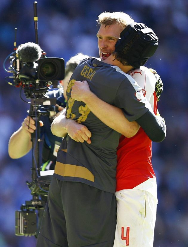 Obránce Arsenalu Per Mertesacker a brankář Petr Čech se objímají po vítězství nad Chelsea.