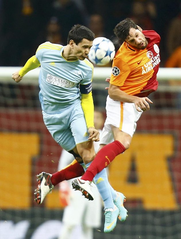 Hakan Balta z Galatasaraye a Foxi Kethevoama z Astany v hlavičkovém souboji o balón.
