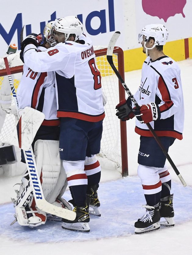 Hvězdný ruský útočník Washingtonu Capitals Alex Ovečkin (8) slaví se spoluhráči výhru nad týmem New York Islanders.