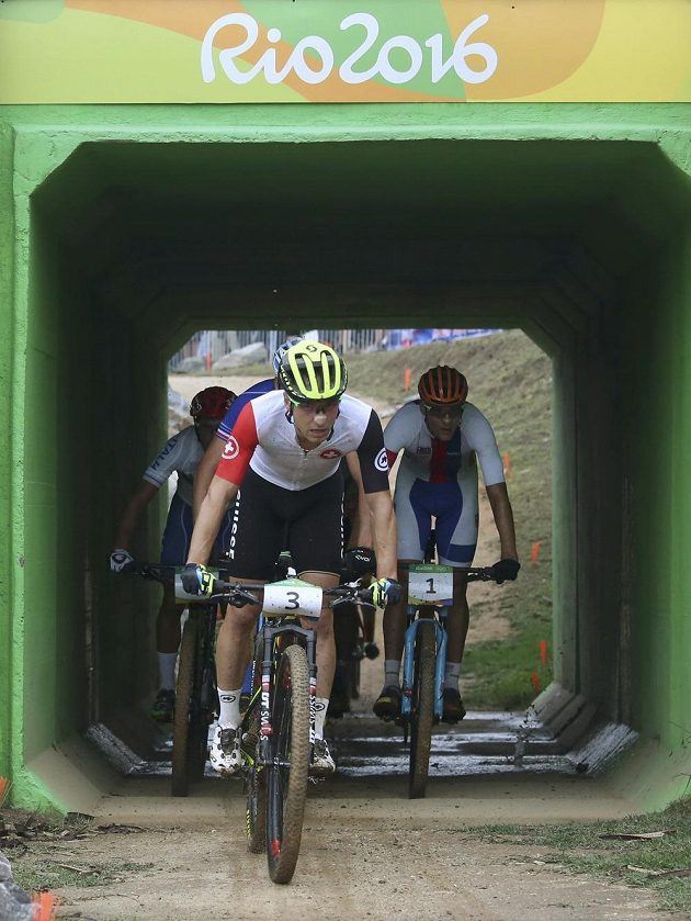 Průjezd tunelem při olympijském závodu bikerů. Na čele Švýcar Nino Schurter, za ním Jaroslav Kulhavý.