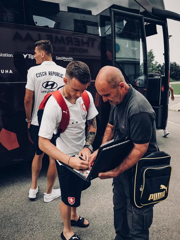 Jan Sýkora rozdává autogramy po příjezdu do Rakouska, v pozadí Patrik Schick.