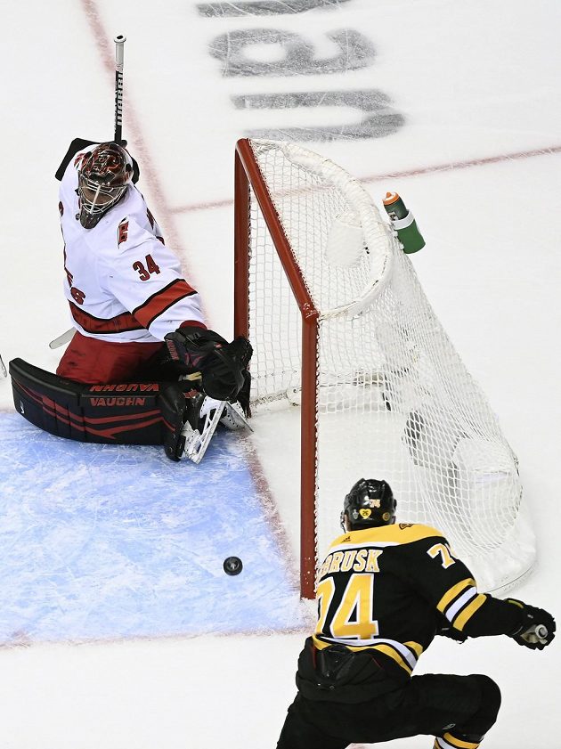 Bostonský Jake DeBrusk (74) se snaží překonat brankáře Caroliny Petra Mrázka.