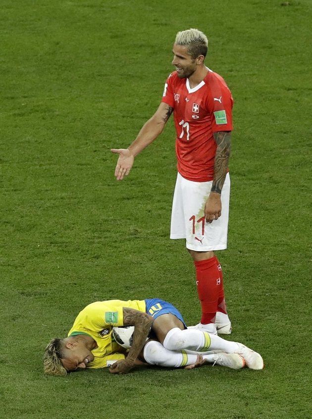 Jen se na něj podívejte! Švýcar Valon Behrami se podivuje nad ležícím Brazilcem Neymarem.