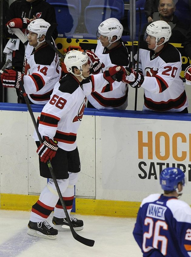 Jaromíru Jágrovi (68) gratuloval po 700. gólu v NHL Ryan Carter (20) a další spoluhráči na střídačce.