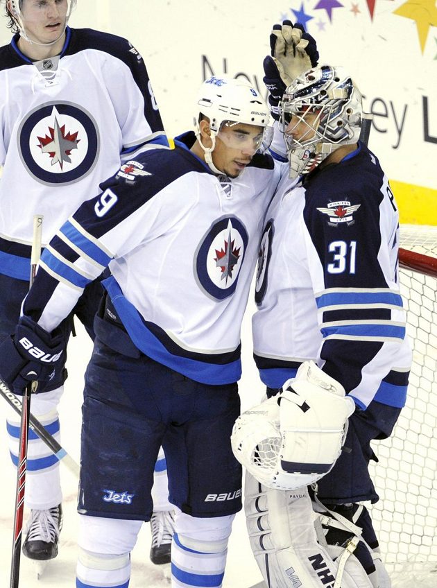 Gólman Winnipegu Ondřej Pavelec (vpravo) přijímá od spoluhráčů gratulace po vyhraném duelu s New Jersey.