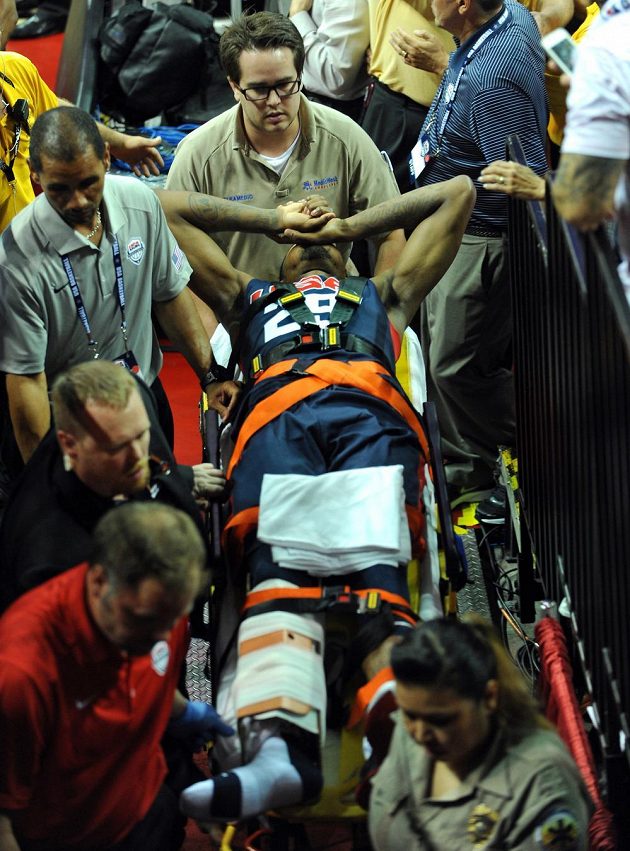 Medici se starají o zraněného basketbalistu George během exhibice v Las Vegas.