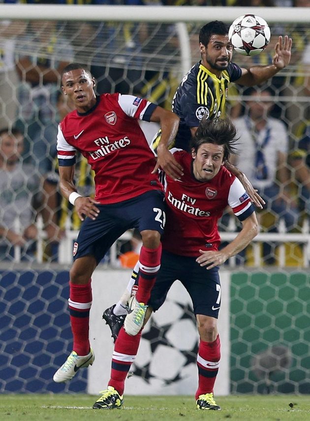 Bekir Irtegün z Fenerbahce v hlavičkovém souboji s dvojicí hráčů Arsenalu Kieran Gibbs a Tomáš Rosický.