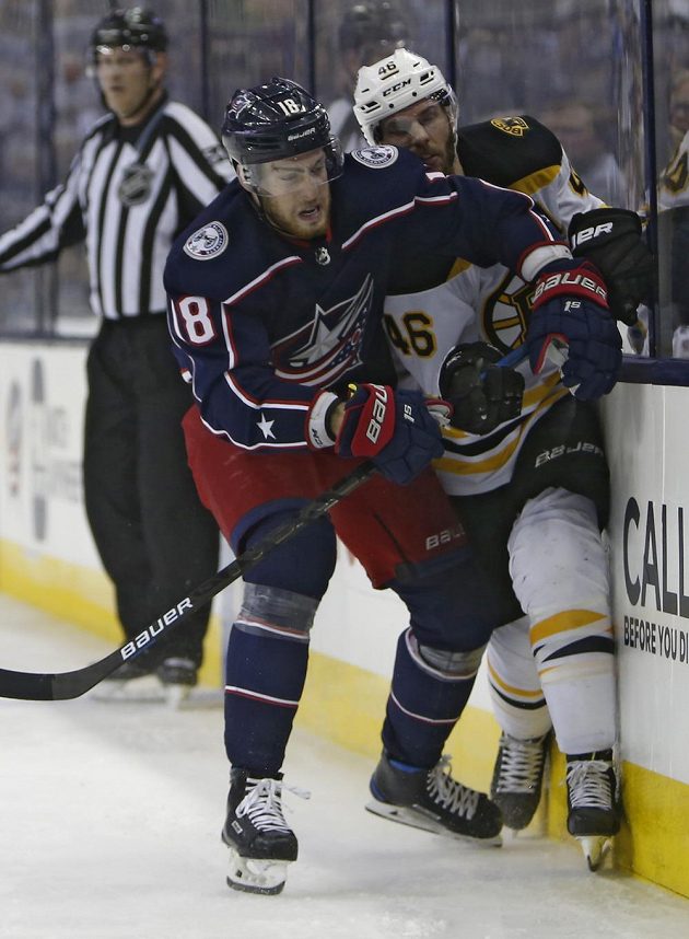 Hokejista Columbusu Blue Jackets Pierre-Luc Dubois v souboji s českým útočníkem Bostonu Davidem Krejčím během utkání play off NHL.