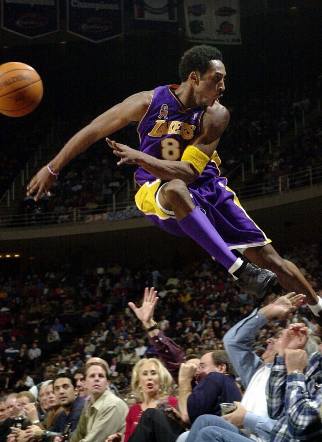 Kobe Bryant na snímku z roku 2001 skáče při jedné z herních situací mezi fanoušky.