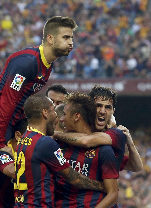 Fotbalista Barcelony Neymar (druhý zprava) se raduje společně s Gerardem Piquem (nahoře), Danim Alvesem a Cescem Fabregasem (vpravo) z gólu do sítě Realu Madrid.