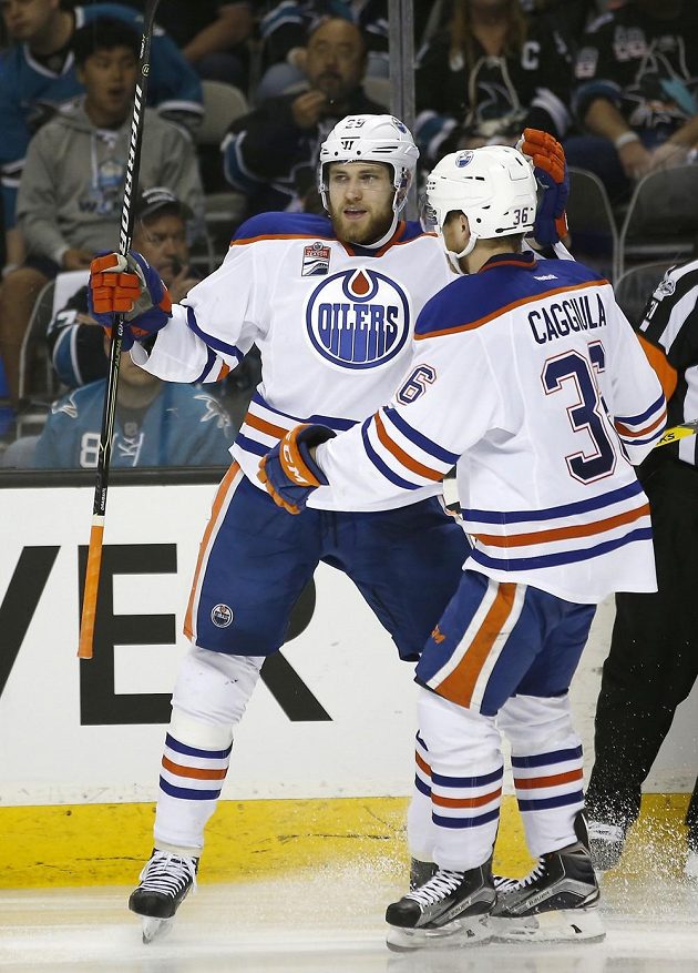 Drake Caggiula (vpravo) gratuluje německému útočníkovi Edmontonu Leonu Draisaitlovi k brance v šestém utkání série se San Jose.