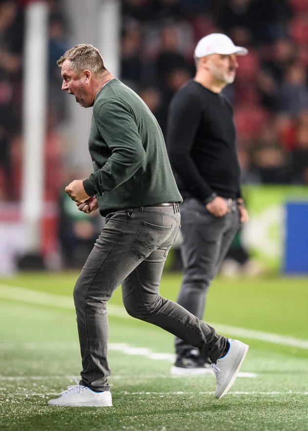 Trenér Sparty Praha Pavel Vrba oslavuje vítězství 1:0 nad Slavií, jeho protějšek Jindřich Trpišovský je za ním zasmušilý.