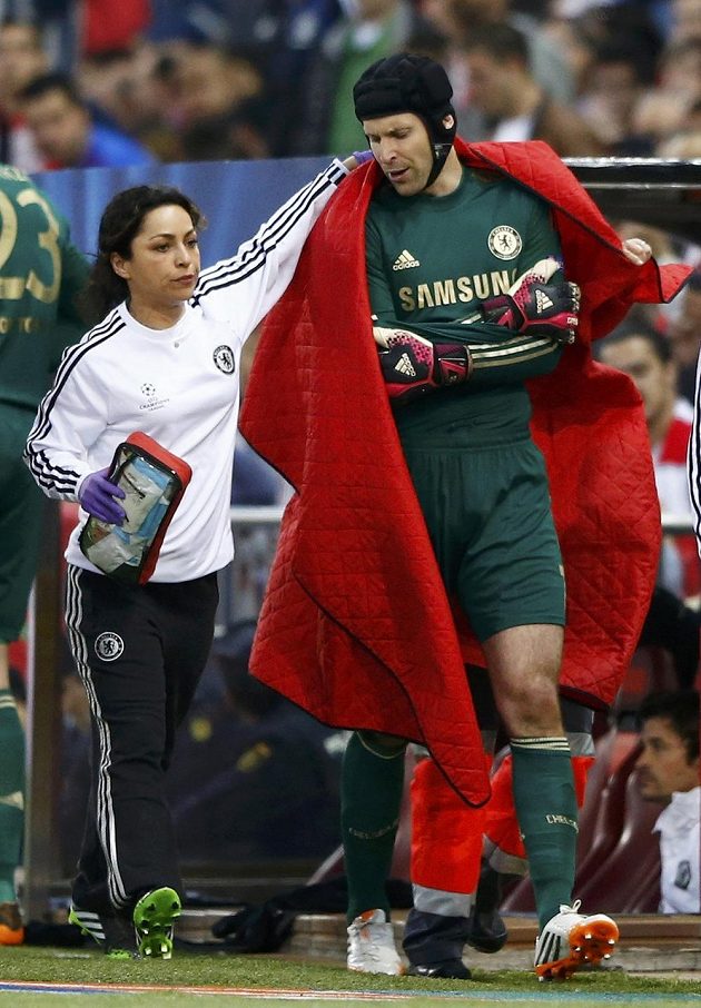 Lékařka Chelsea doprovází zraněného Petra Čecha z hrací plochy v úvodním semifinále Ligy mistrů proti Atlétiku Madrid.