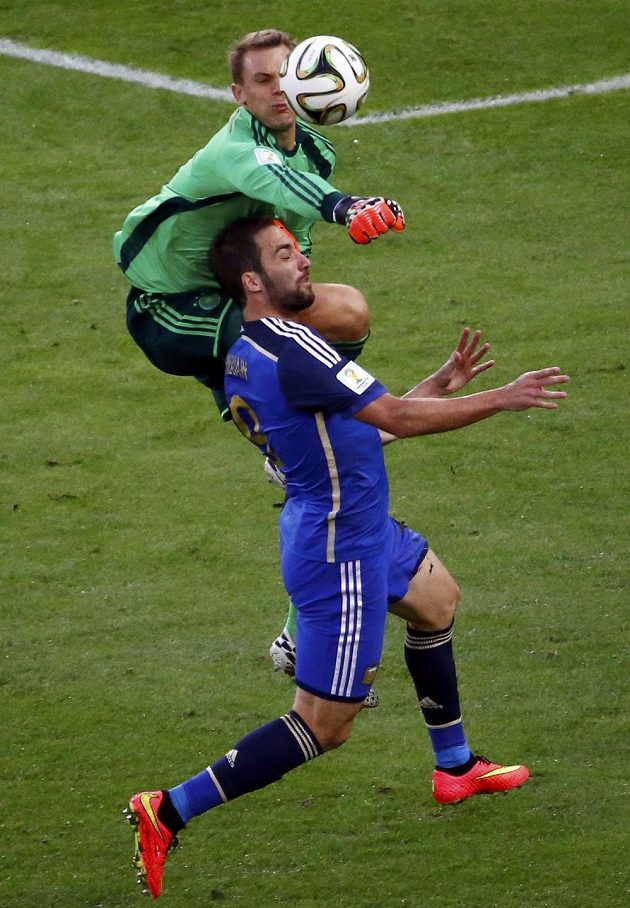 Německý brankář Manuel Neuer vyboxovává míč před argentinským útočníkem Higuaínem (v modrém dresu).