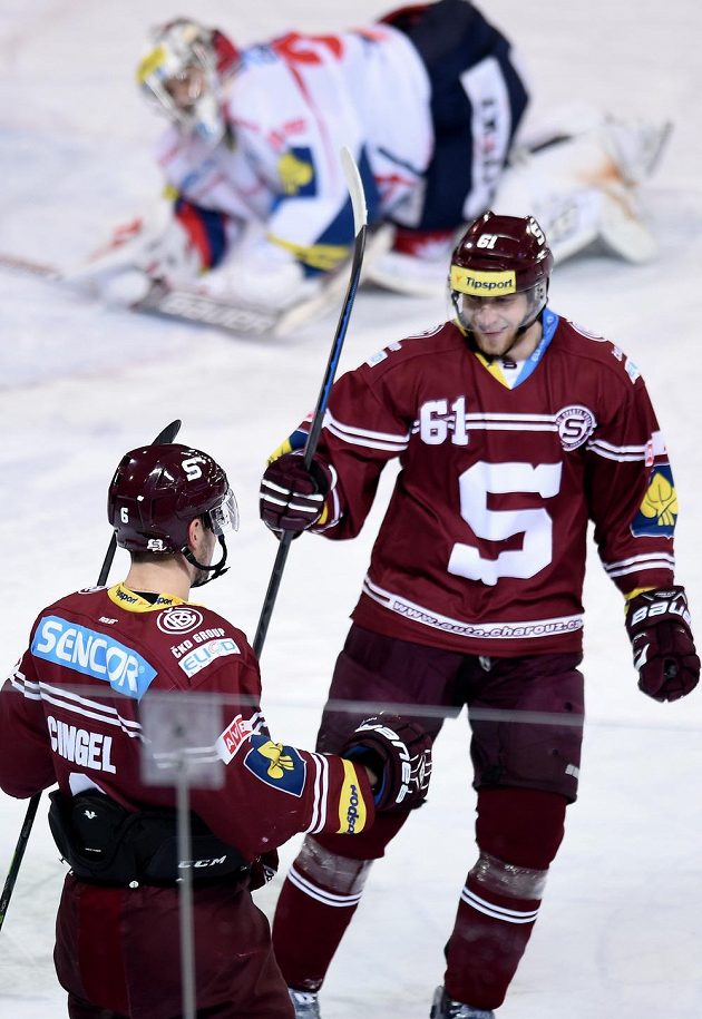 Sparťané Lukáš Cingel (zády) a Lukáš Klimek oslavují druhý gól proti Pardubicím ve 23. kole extraligy.