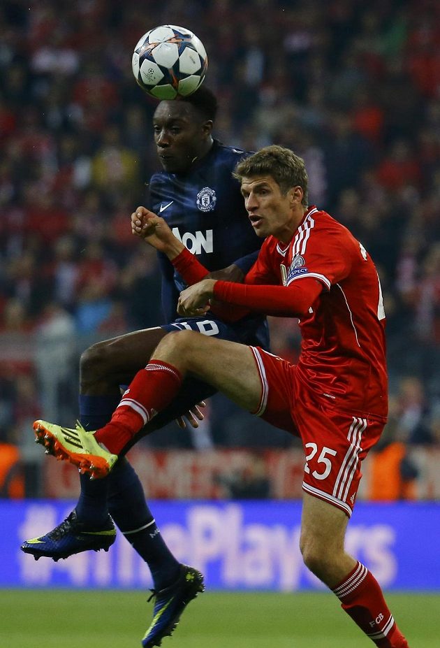 Thomas Müller z Bayernu Mnichov (v červeném dresu) v hlavičkovém souboji s útočníkem Rudých ďáblů Dannym Welbeckem.