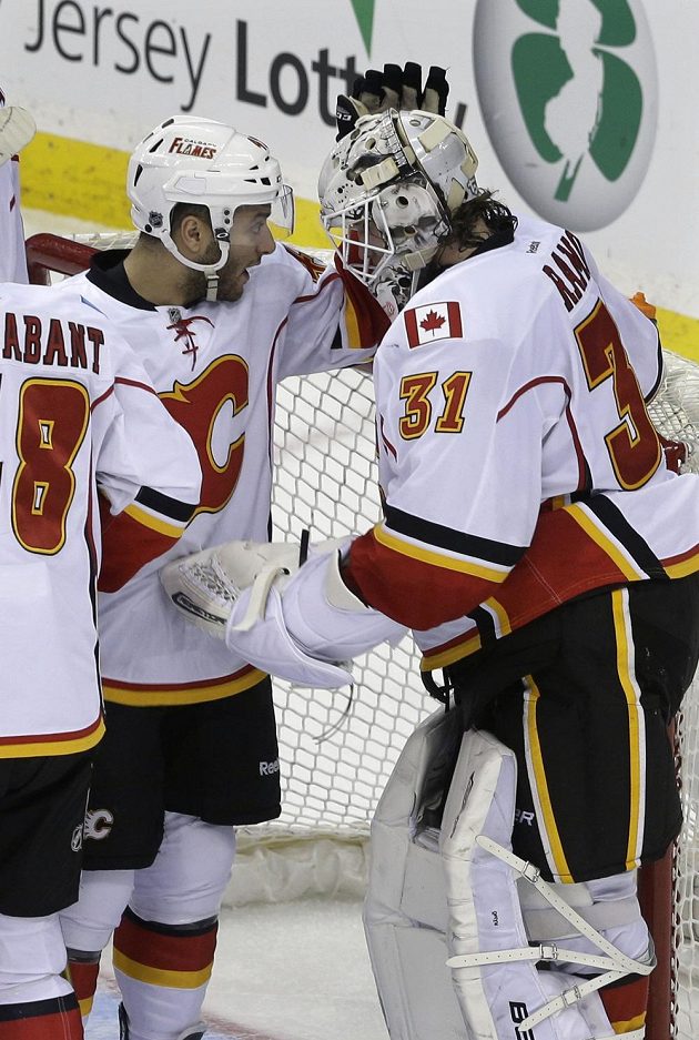 Brankář Calgary Karri Rämö slaví se spoluhráčem Markem Cundarim výhru v New Jersey.